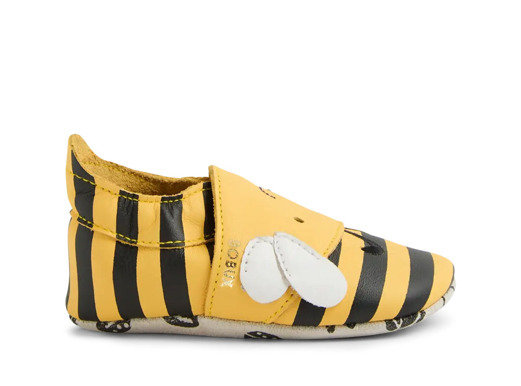 Sapato Bobux Bugbee Abelha, vista lateral, com riscas amarelas e pretas, asa branca e sola flexível.