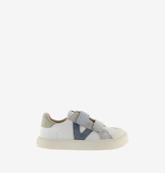 Sapatilha infantil estilo ténis, cor branca com detalhes em azul escuro e cinzento claro, fecho de velcro duplo, vista lateral.