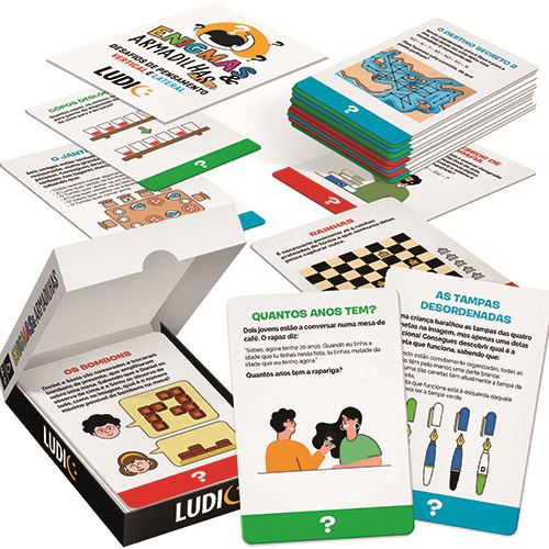 Conjunto de cartas do jogo "Enigmas & Armadilhas" espalhadas, mostrando exemplos de desafios como "Os Bombons", "Rainhas" e "Quantos Anos Tem?", juntamente com a caixa aberta.