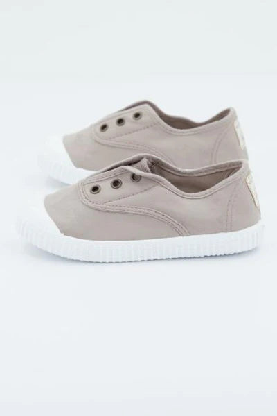 Par de sapatilhas Victoria de lona Hielo 20 de cor bege claro com elástico e sola branca, vistas de lado, ideais para crianças.