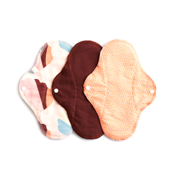 Conjunto de três pensos menstruais diários ImseVimse SPRINKLE Rosa, exibindo diferentes padrões e cores, com botões de pressão visíveis para fixação.