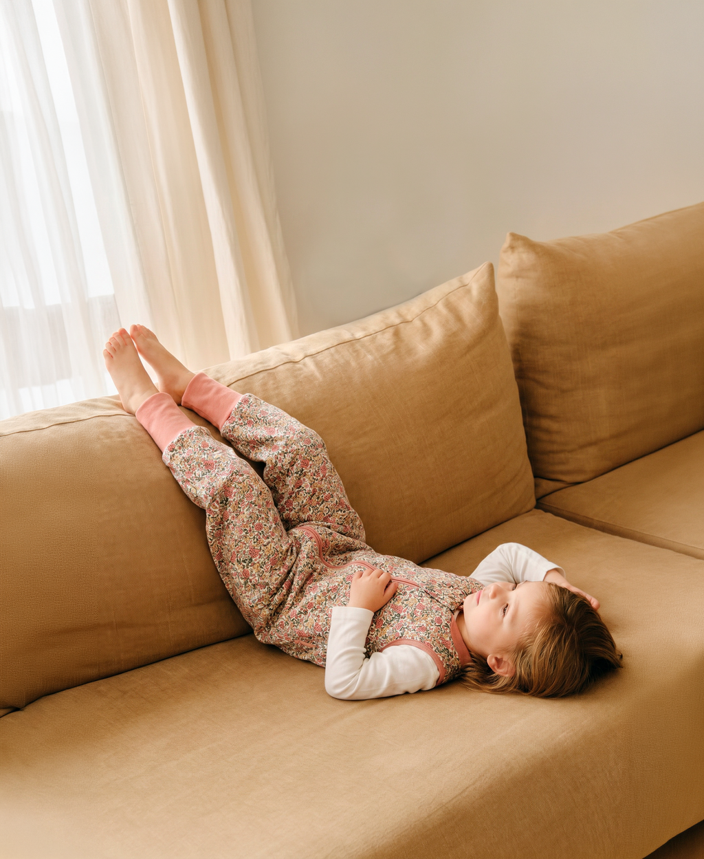 Pijama manta MolisandCo TOG 1.0 com pés e meias antiderrapantes na cor Peony, vestido por uma criança