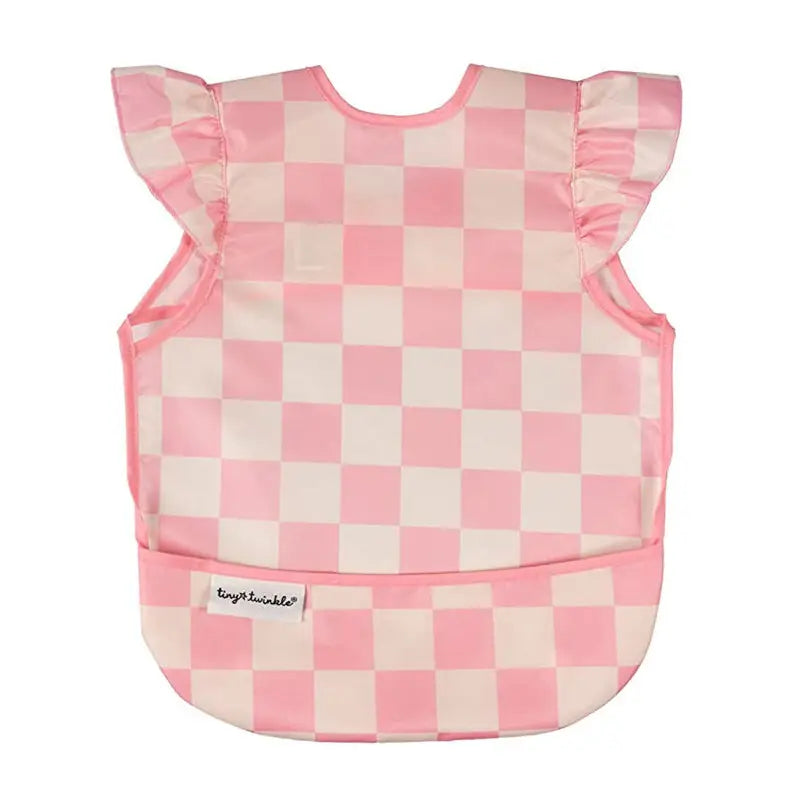 Babete impermeável Tiny Twinkle Quadrados Rosa com folhos nos ombros e bolso frontal, em poliéster reciclado.