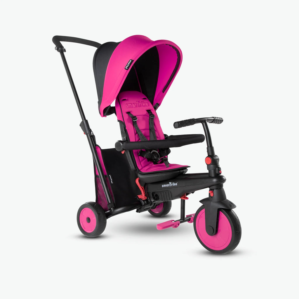 Triciclo evolutivo SMARTRIKE 5-em-1 STR3 em rosa, configurado como carrinho de passeio com pega parental e capota de sol.