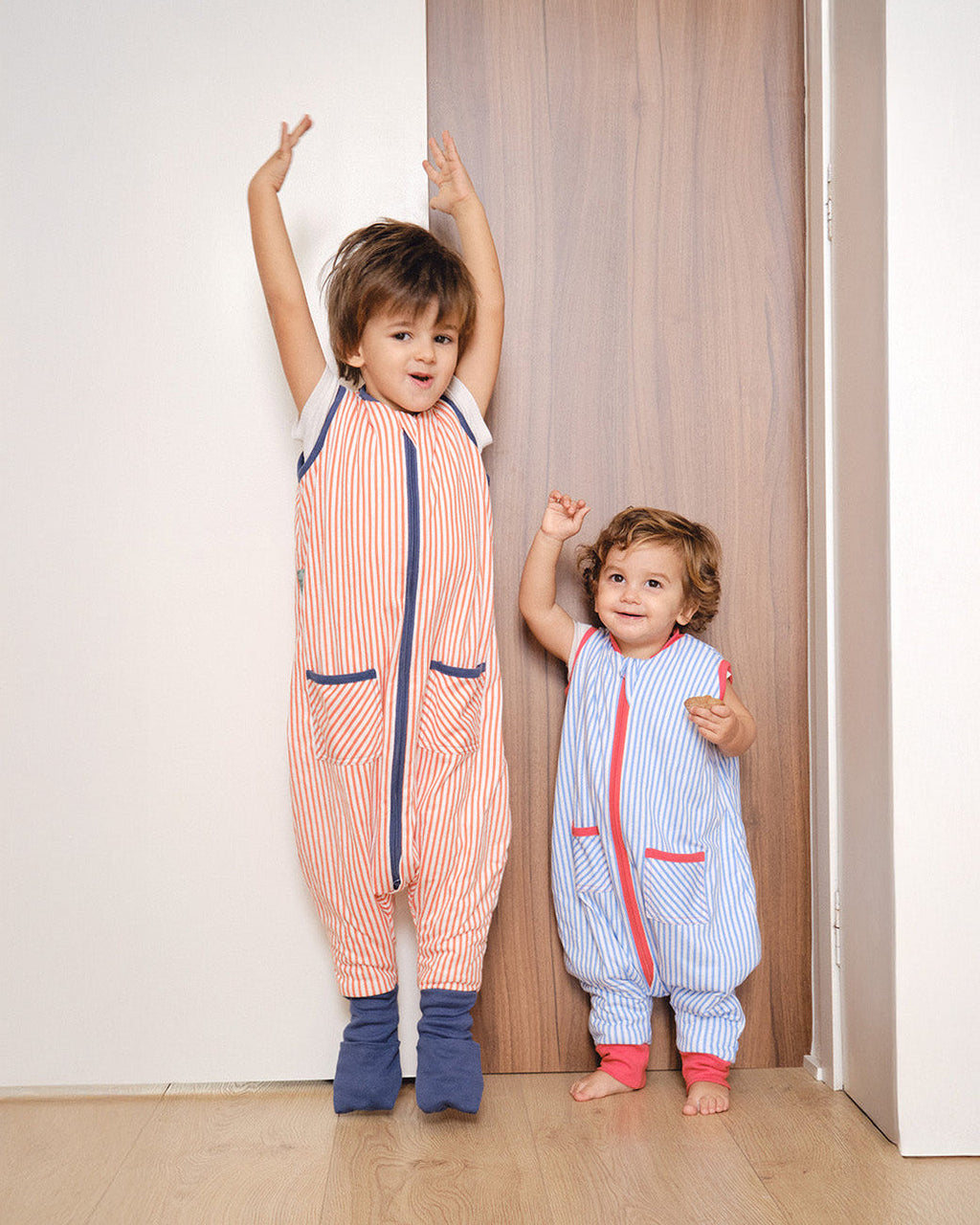 Pijama manta MolisandCo TOG 1.0 com pés e meias antiderrapantes na cor Sailor Orange, vestido por uma criança
