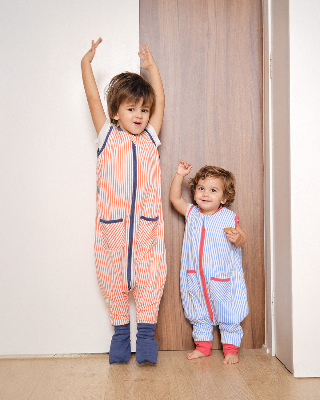 Pijama manta MolisandCo TOG 1.0 com pés e meias antiderrapantes na cor Sailor Orange, vestido por uma criança