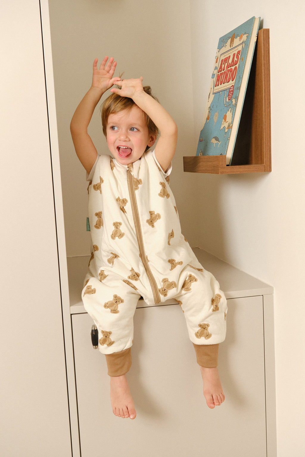 Criança vestida com o saco de dormir MolisandCo TOG 1.0 com pés no padrão Teddy
