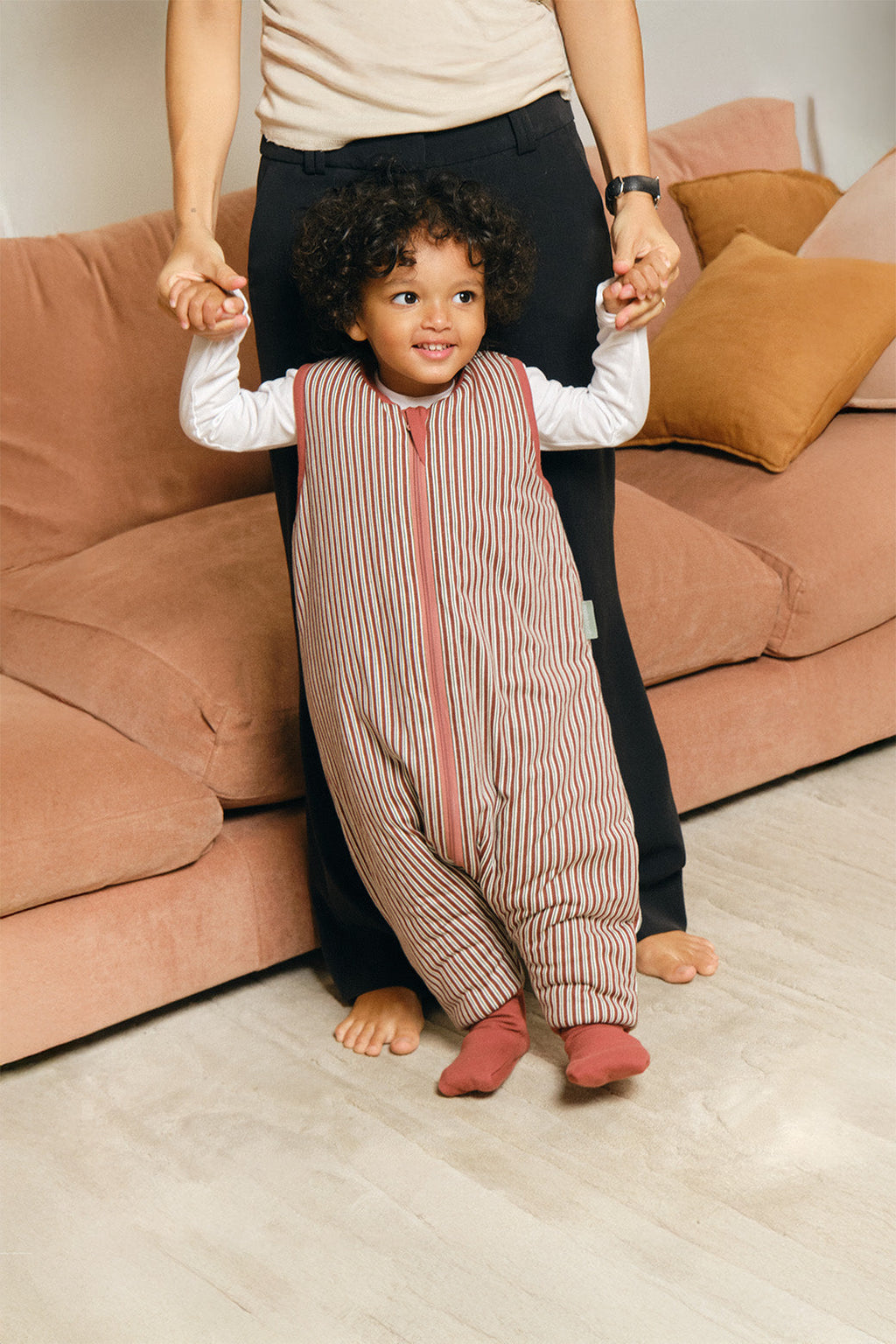 Pijama manta MolisandCo TOG 2.5 com pés e meias antiderrapantes na cor Burgundy Stripes, vestido por uma criança