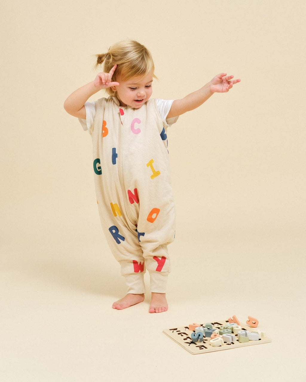 Saco de dormir MolisandCo TOG 1.0 com pés ABC vestido sobre o pijama, em uso pela criança