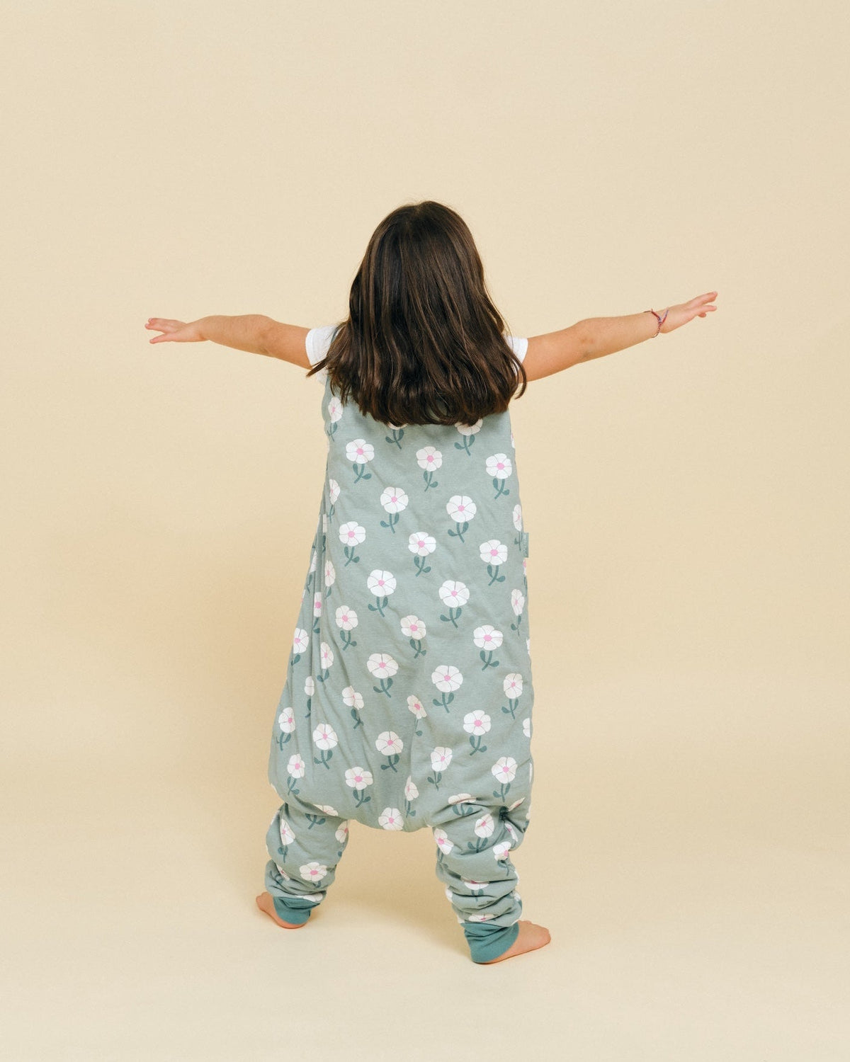 Saco de dormir MolisandCo TOG 1.0 com pés Sakura Garden vestido sobre o pijama, em uso pela criança