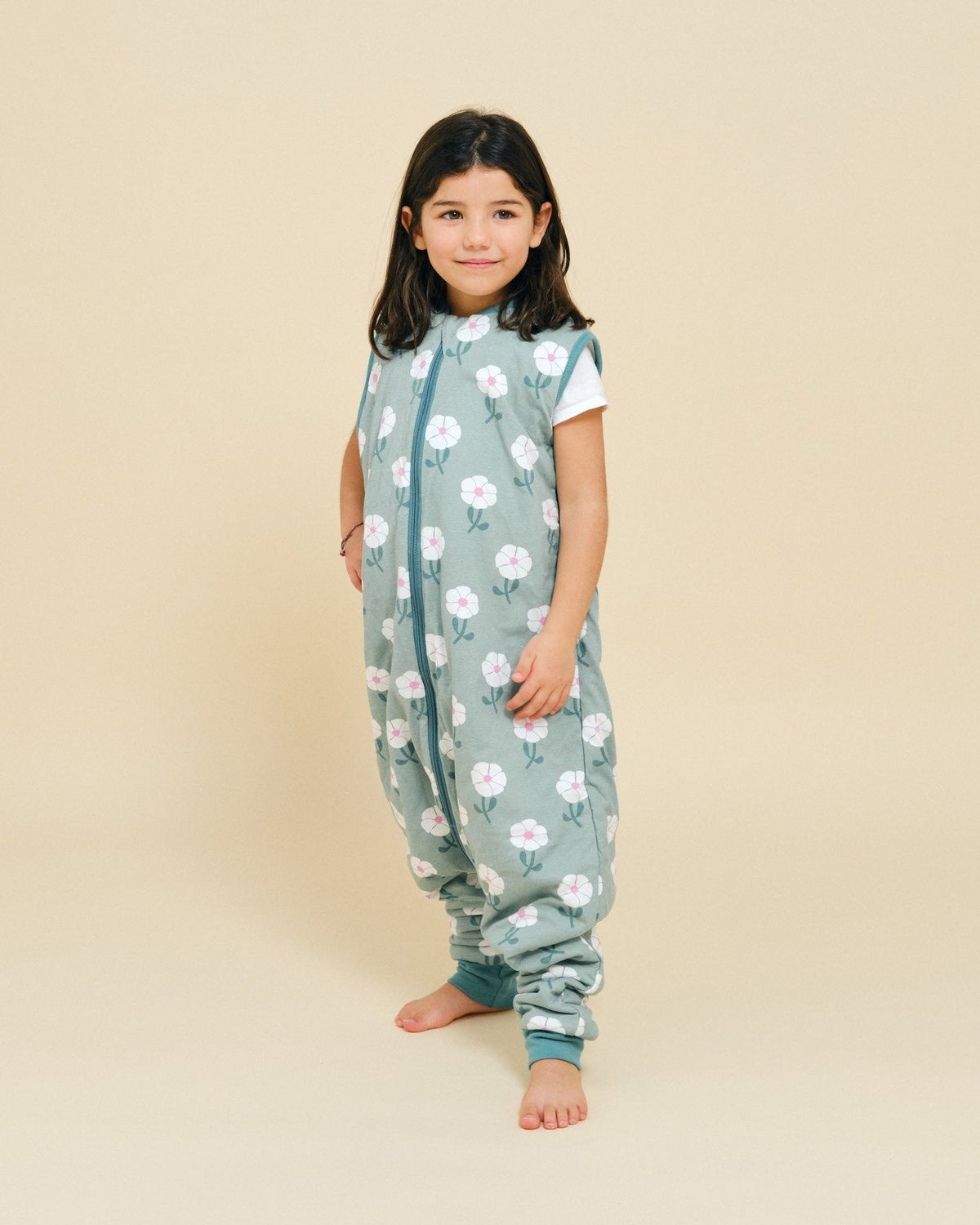 Criança vestida com o saco de dormir MolisandCo TOG 1.0 com pés no padrão Sakura Garden
