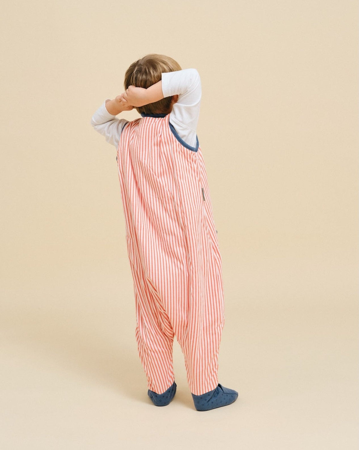 Pijama manta MolisandCo TOG 1.0 com pés e meias antiderrapantes na cor Sailor Orange, vestido por uma criança