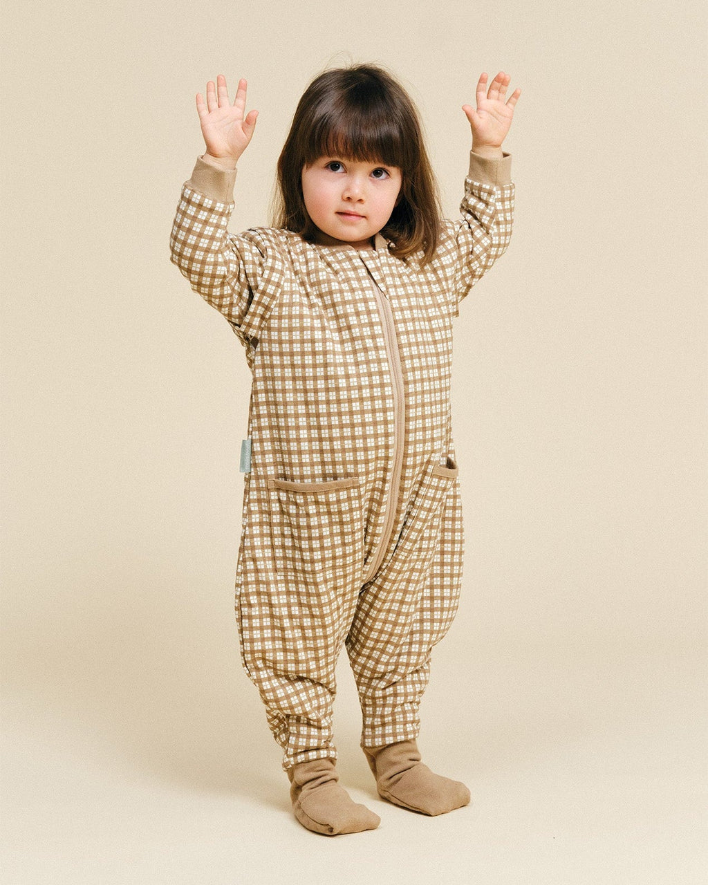 Pijama manta MolisandCo TOG 1.0 com pés e mangas na cor Brown Checks, vestido por uma criança