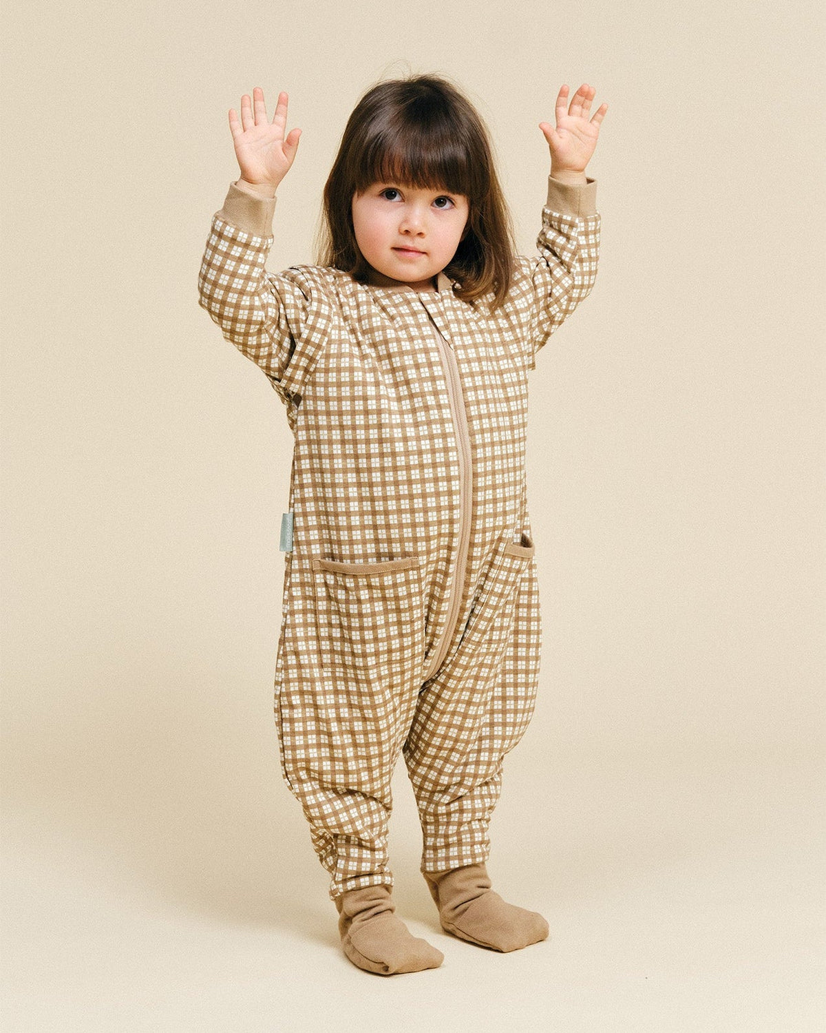 Pijama manta MolisandCo TOG 1.0 com pés e mangas na cor Brown Checks, vestido por uma criança