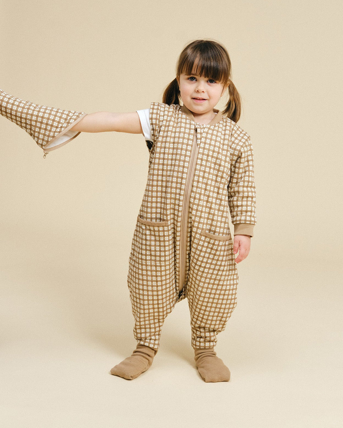 Pijama manta MolisandCo TOG 1.0 com pés e mangas na cor Brown Checks, vestido por uma criança