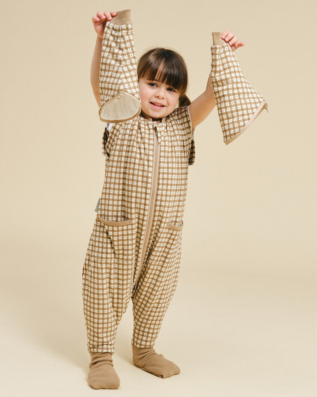 Pijama manta MolisandCo TOG 1.0 com pés e mangas na cor Brown Checks, vestido por uma criança