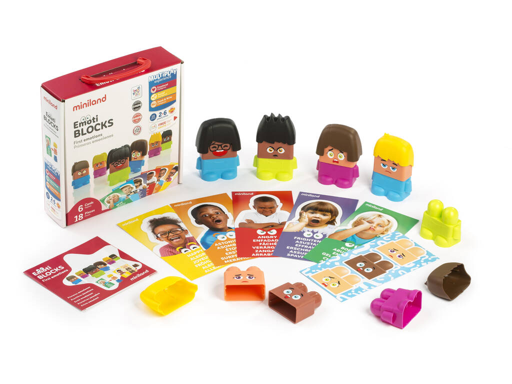 Conjunto completo do Miniland Jogo de Blocos Emoções com a caixa, peças soltas e cartas de atividades espalhadas sobre uma superfície branca.