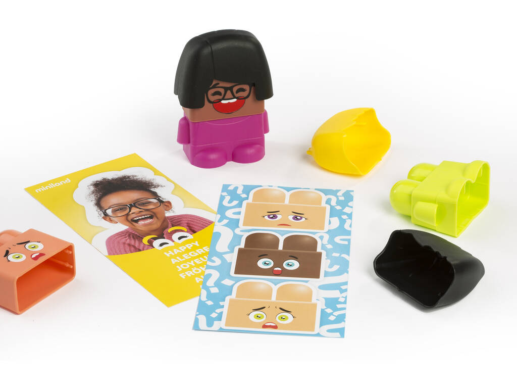 Detalhe de uma personagem "Emoti Block" com expressão de alegria e uma carta de atividade que mostra uma criança feliz e a palavra "HAPPY".
