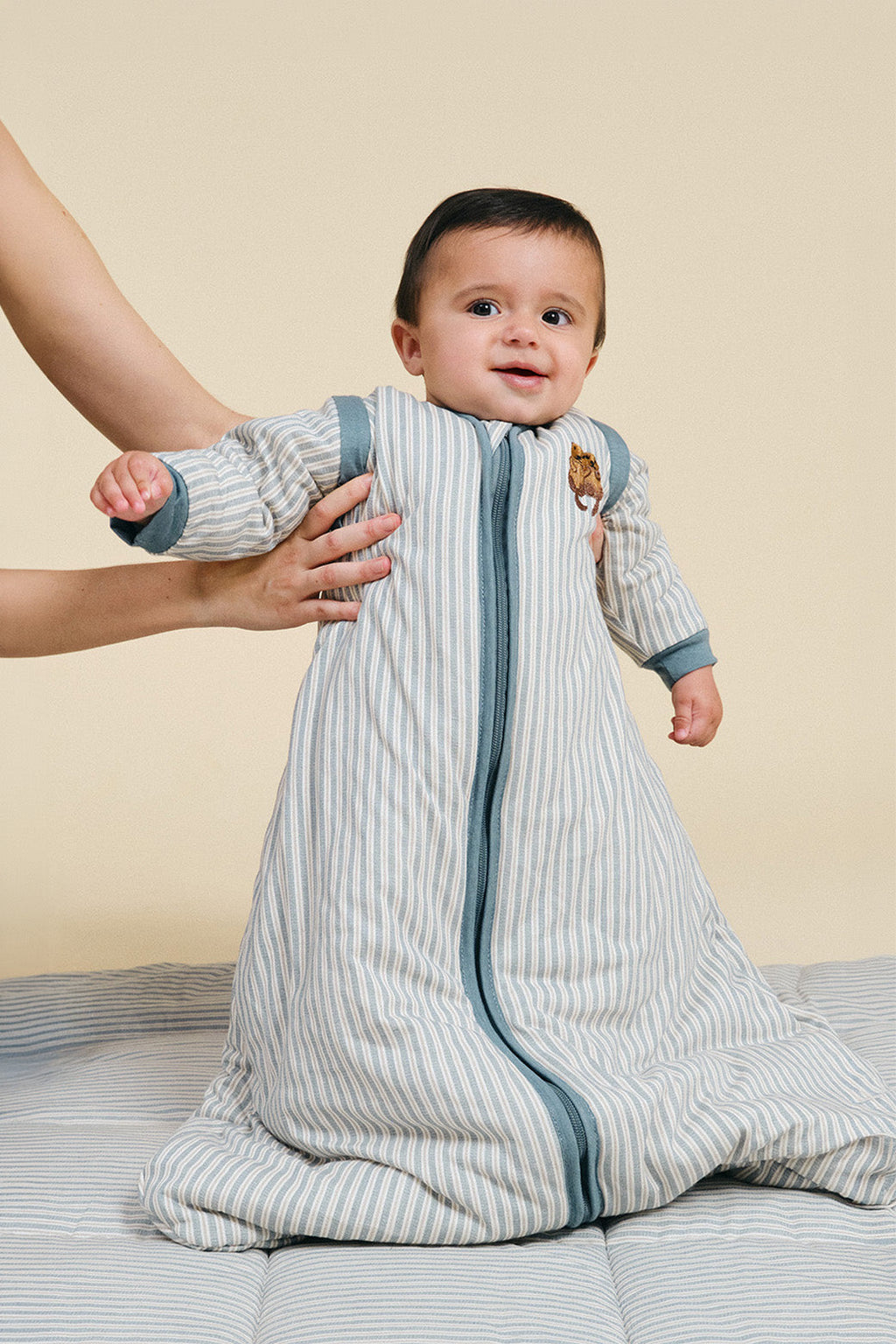 Saco de dormir de bebé MolisandCo TOG 2.5 com mangas no padrão Blue Stripes, visto de frente