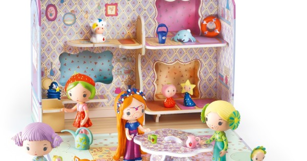 Close-up do interior da Casa Caravana Djeco Tinyly com várias figurinhas, incluindo Bluchka, a interagir com a mesa e os acessórios, demonstrando o potencial de brincadeira.