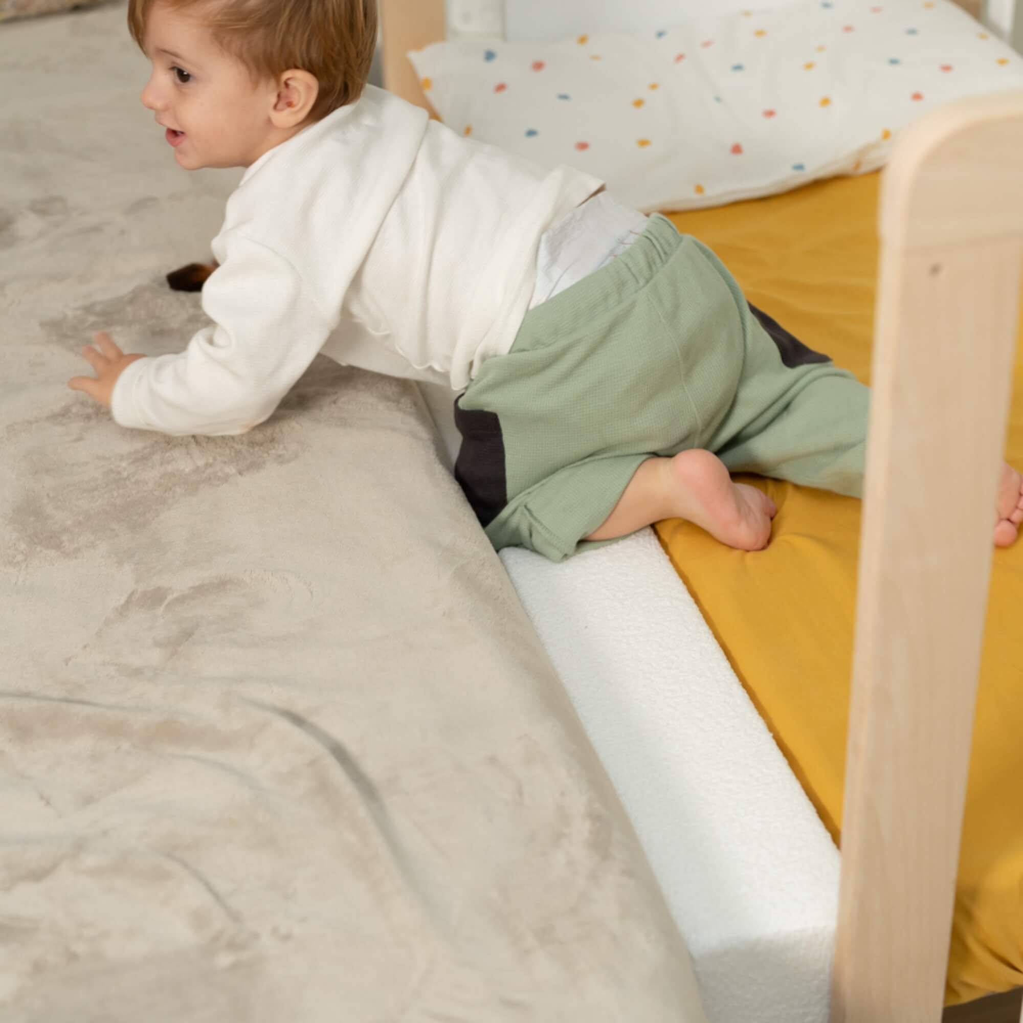 Um bebé de gatas a transitar de uma cama de adulto para um berço Micuna, mostrando a funcionalidade do co-sleeping.