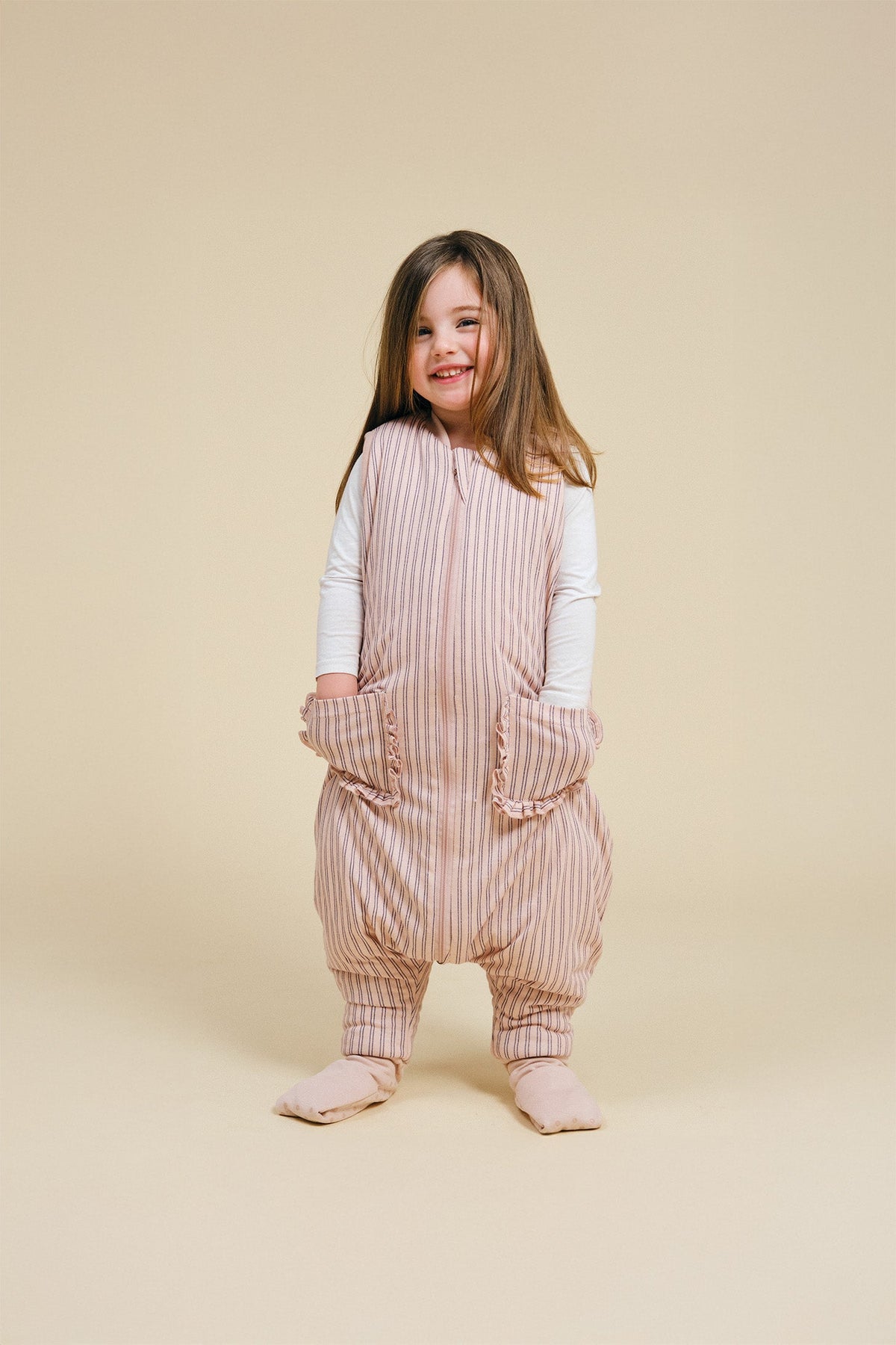 Pijama manta MolisandCo TOG 2.5 com pés e meias antiderrapantes na cor Navy and Pink Stripes, vestido por uma criança