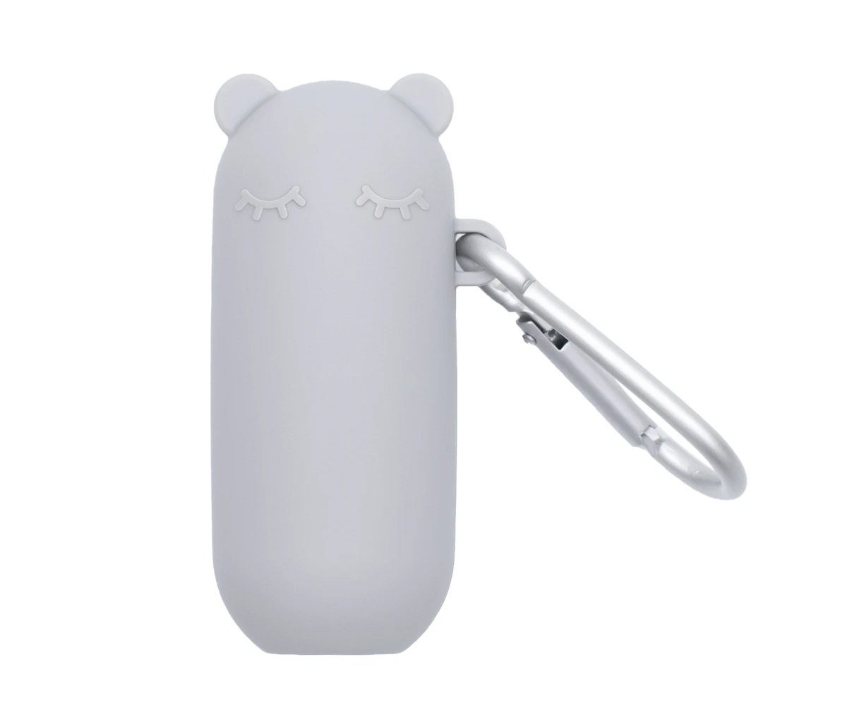 Detalhe do estojo cinzento We Might Be Tiny Keepie em forma de urso com mosquetão de alumínio, sobre fundo branco.