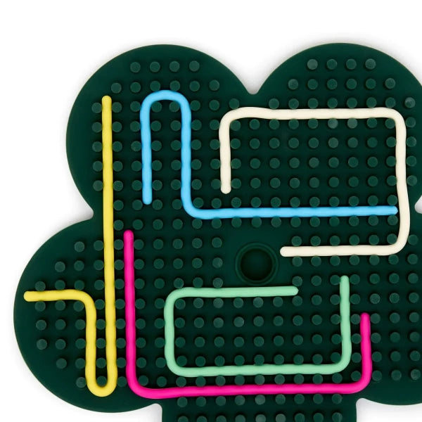 Vista superior do Miniland Flexihetti Flower, mostrando a base verde com orifícios e esparguetes de silicone coloridos encaixados.
