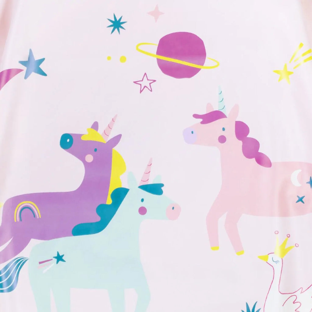 Detalhe aproximado do padrão de unicórnios, estrelas e planetas no babete Miniland, em tons pastel.