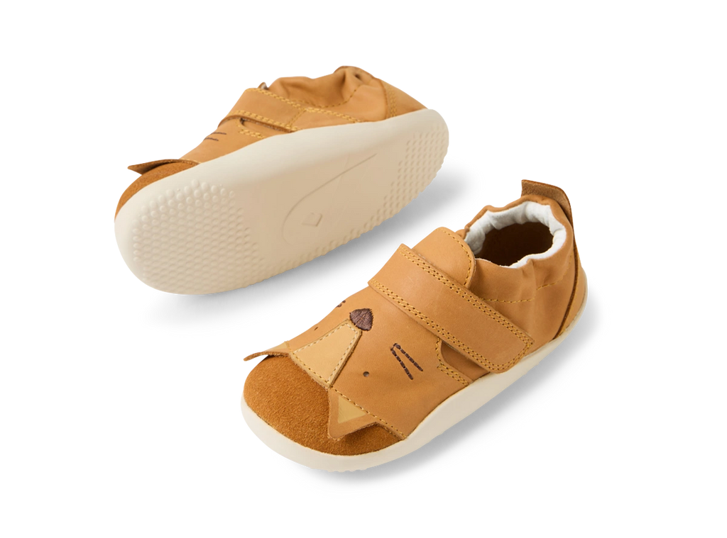 Par de sapatos Bobux Xplore Rummage Pumpkin para bebé, com sola flexível visível e design de face de animal na biqueira, vistos de cima.