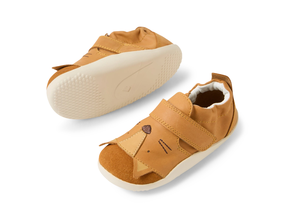 Par de sapatos Bobux Xplore Rummage Pumpkin para bebé, com sola flexível visível e design de face de animal na biqueira, vistos de cima.