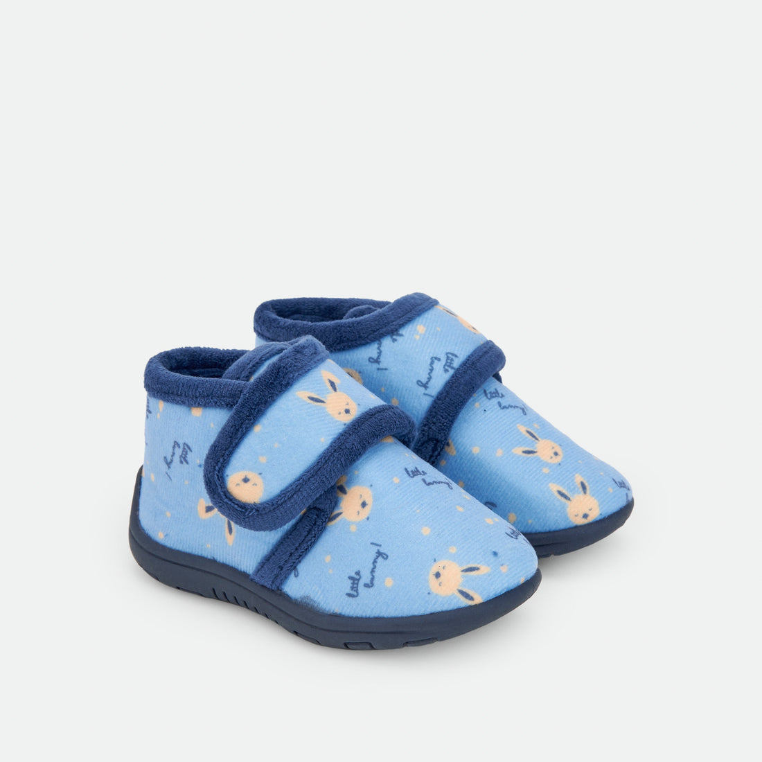 Pantufas azul-vivas com pequenos desenhos e fecho de velcro.