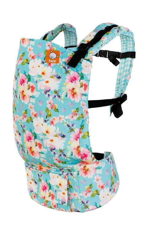 Imagem de uma mochila porta-bebé Tula Standard - Spring Bouquet, com um padrão floral em tons de azul, rosa e branco. A mochila apresenta alças ajustáveis e acolchoadas.