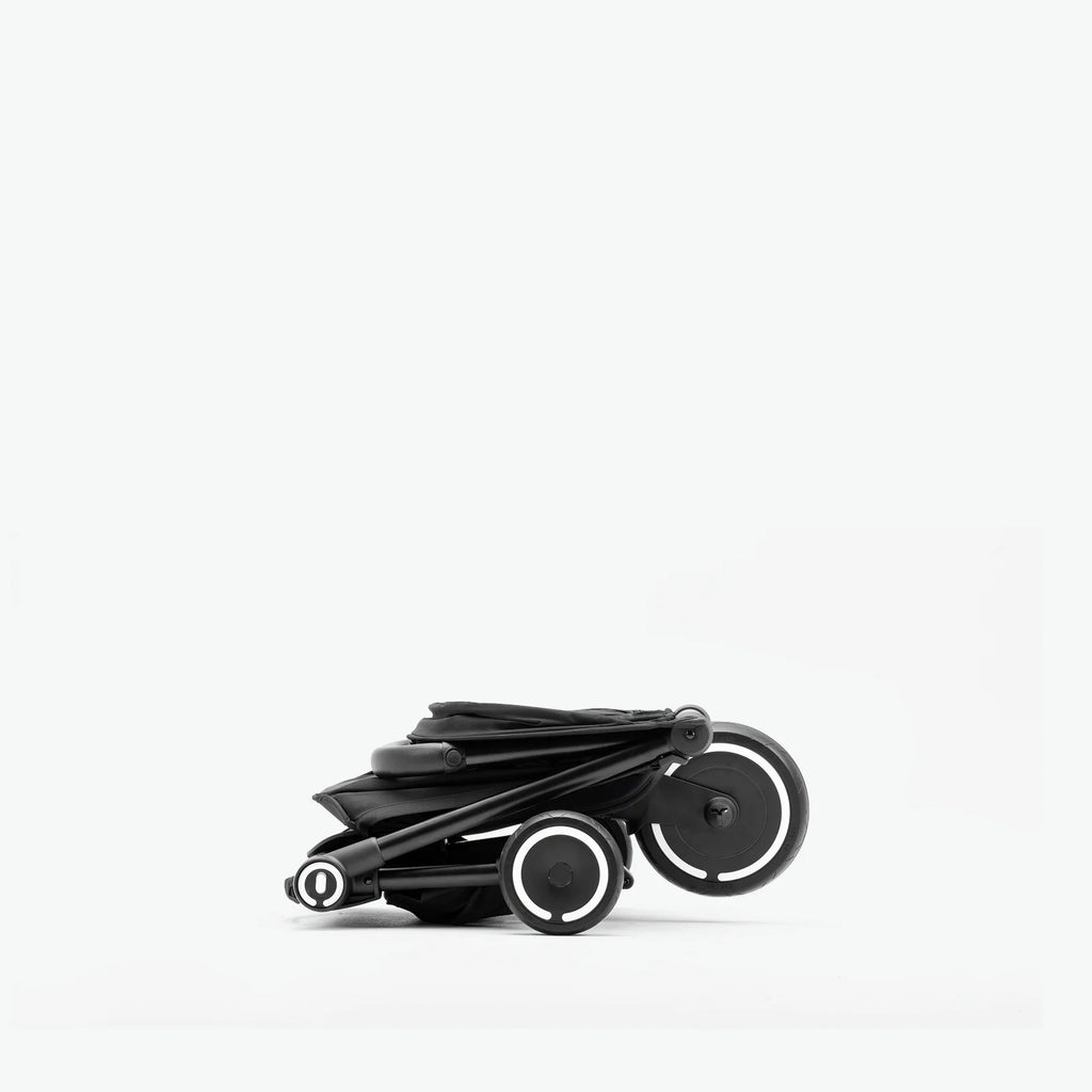 Smartrike Traveler totalmente dobrado, mostrando o formato ultracompacto ideal para arrumação e viagem.