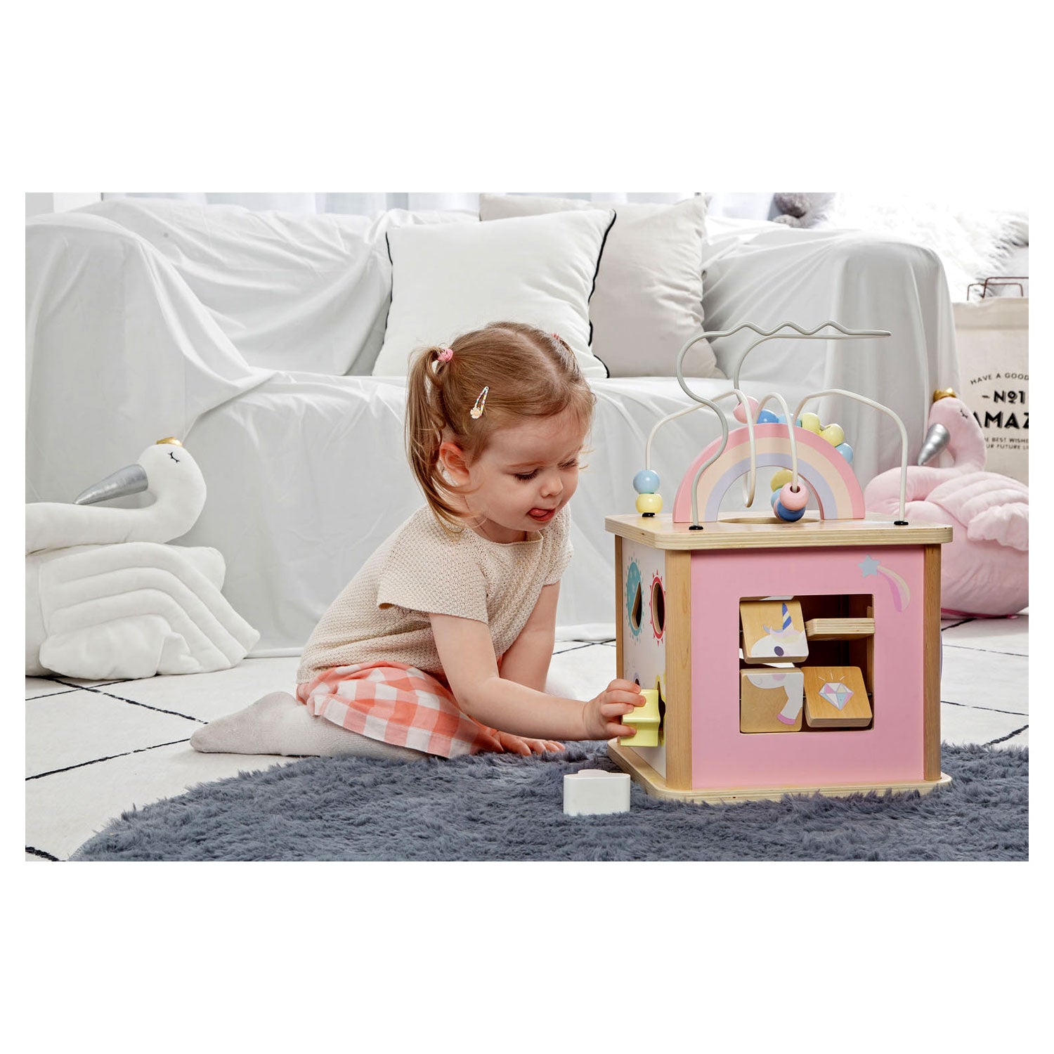 Criança pequena a brincar com o cubo de atividades Classic World, interagindo com o puzzle de unicórnio.