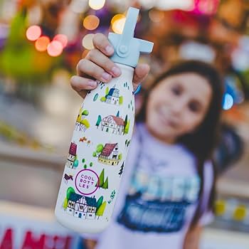 Criança sorridente a segurar a garrafa térmica Cool Bottles Tudor Village 350ml com tampa de palhinha, em ambiente exterior desfocado.