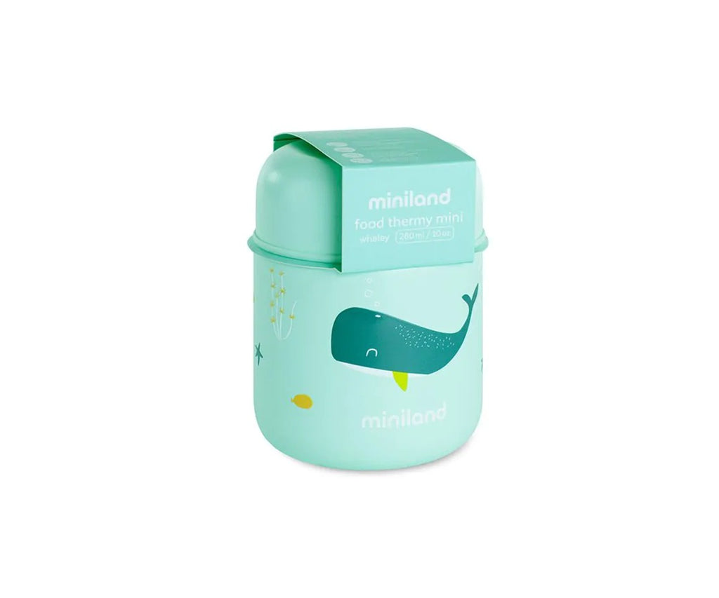 Bebé a ser alimentado com uma colher, com o termo Miniland Whaley 280 ml aberto e um recipiente adicional na mesa.