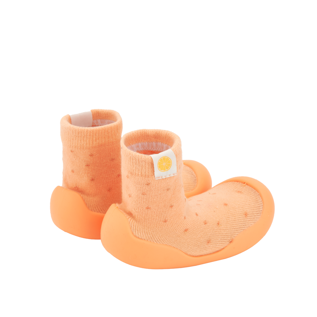 Pantufas tipo meia laranja com sola laranja, similares às da imagem 6. Confortáveis e maleáveis para o desenvolvimento saudável do pé.
