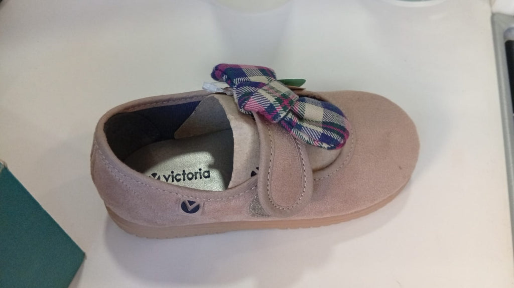 Vista lateral do Victoria Sapato com laço em camurça Bege, mostrando a marca Victoria, o fecho em velcro e a sola flexível.