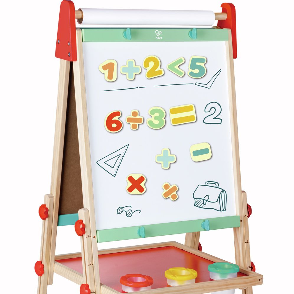 Conjunto de números e símbolos magnéticos Hape coloridos aplicados num cavalete de quadro branco, mostrando equações simples e símbolos matemáticos.