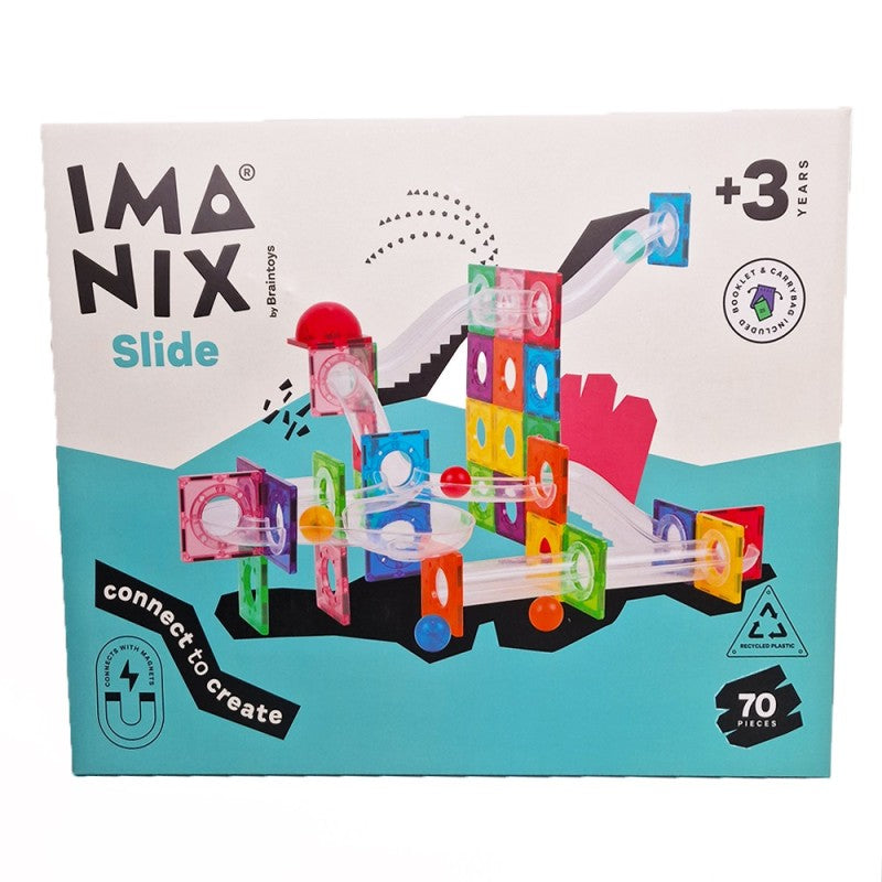 Criança a brincar no chão com blocos magnéticos BRAINTOYS IMANIX e peças de escorrega, a construir uma pista complexa.