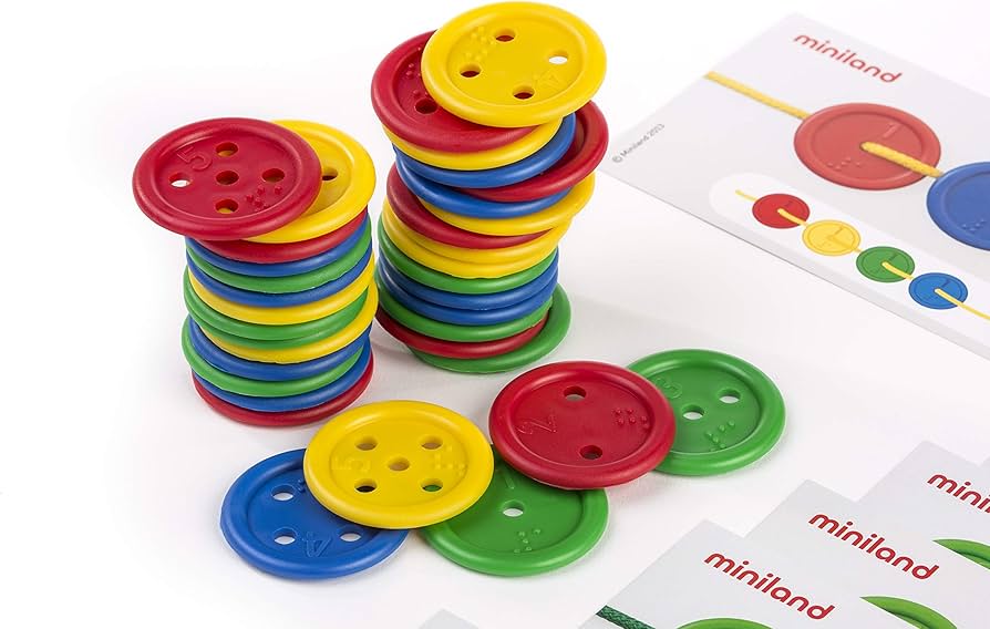 Botões coloridos Miniland Atividades com Botões empilhados e espalhados, com símbolos Braille e cartas de atividades, focando na aprendizagem tátil e matemática.