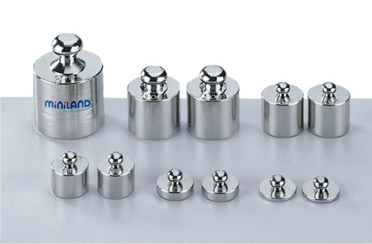 Conjunto de pesos de metal Miniland para balanças educativas, com diferentes tamanhos e pesos, ideal para aprender medição e equilíbrio.