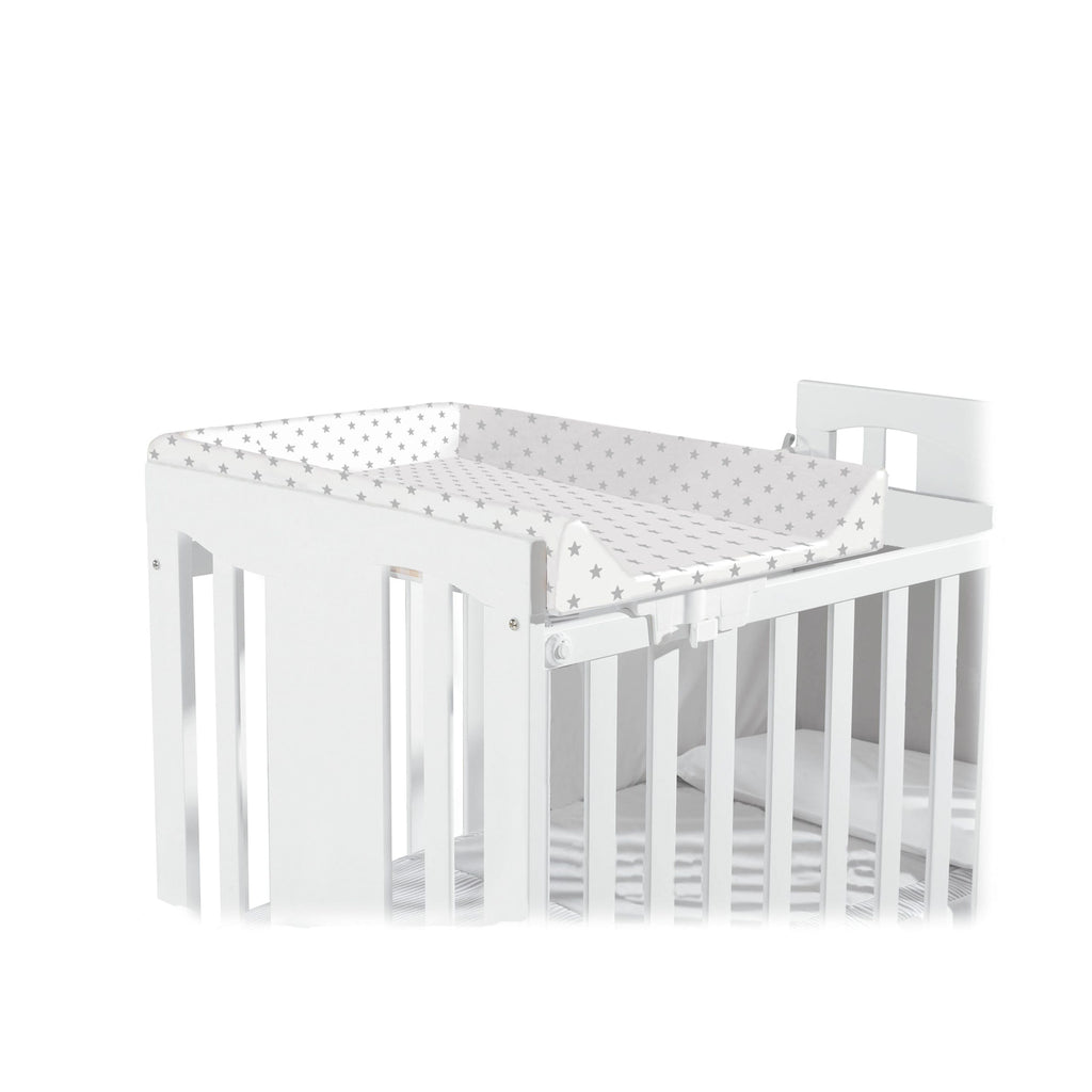 Micuna Trocador de berço de 120x60 com padrão de estrelas cinza, montado num berço branco, mostrando o seu design compacto.