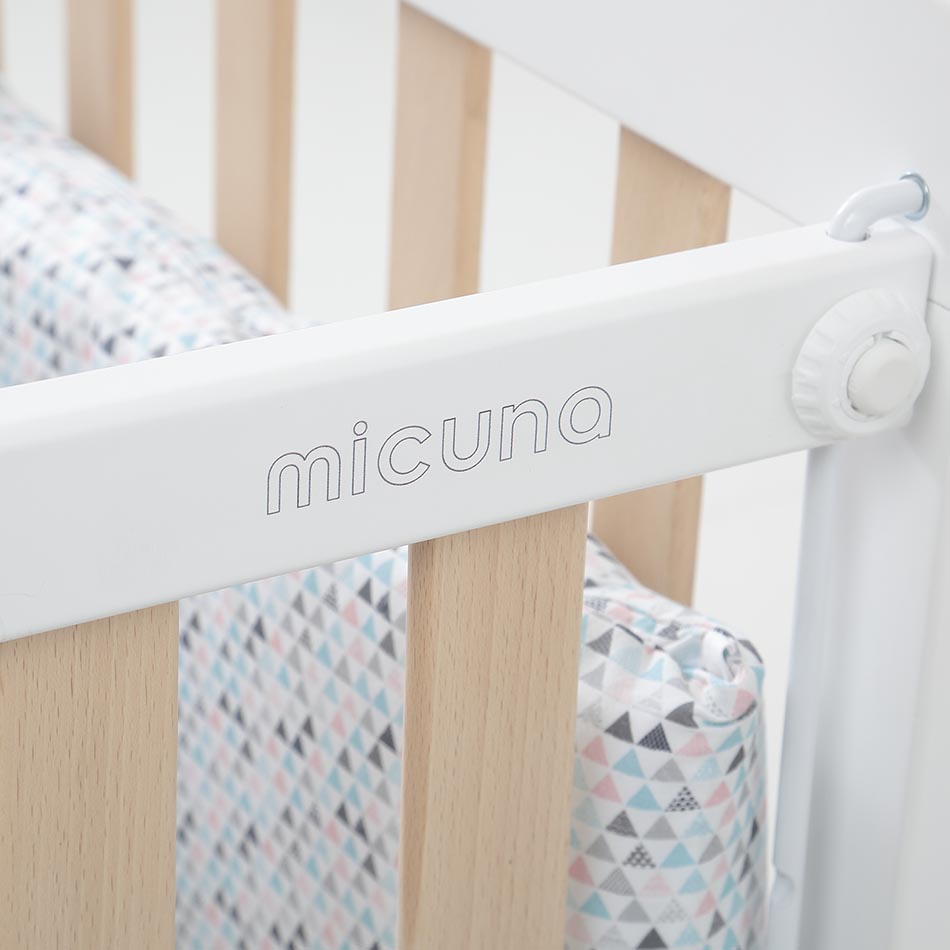 Detalhe do logótipo "micuna" na lateral branca do Micuna Nordika Berço, mostrando a qualidade de construção.