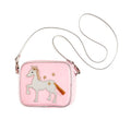 Mala tiracolo infantil cor-de-rosa da Souza Pauline com um aplique de cavalo branco, crina dourada e cauda em franja, alça fina prateada e fundo branco.