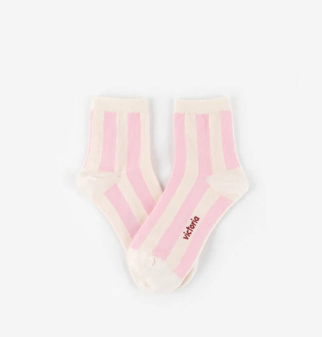 Par de meias curtas de algodão com riscas verticais cor-de-rosa suave e brancas, sobre fundo branco. O nome 'Victoria' está bordado na zona do calcanhar.