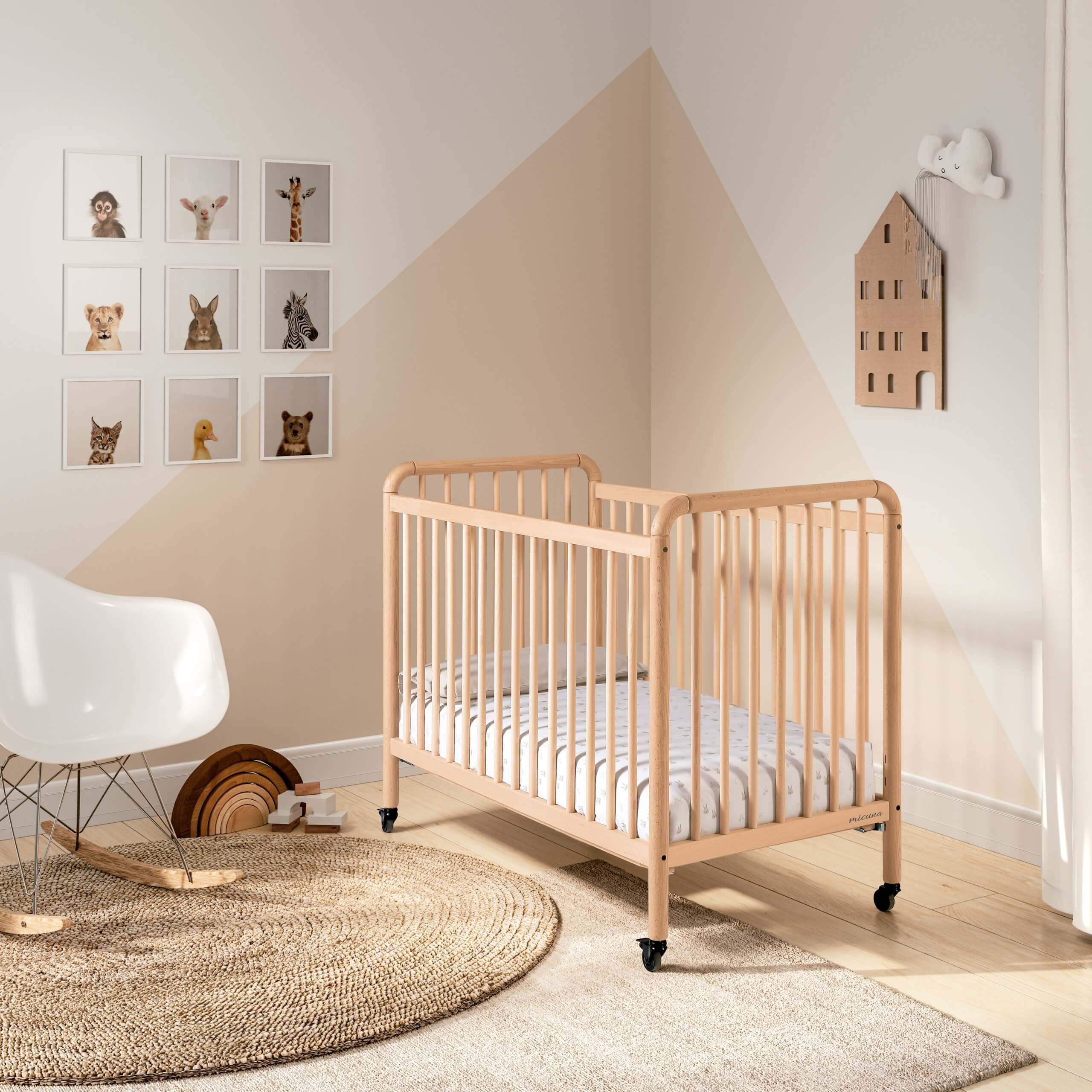 Berço Micuna Meri 120x60 em madeira de faia num quarto de bebé moderno com decoração suave e quadros de animais.