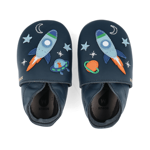 Par de sapatos Bobux Cosmic Rocket Soft Sole em azul-marinho, vistos de cima, com foguetões, estrelas e um OVNI bordados.