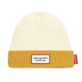 Vista frontal do gorro Hello Hossy Grandma Curry, com a parte superior creme e a dobra inferior em tom mostarda/curry, e o emblema "Cool Kids Only".